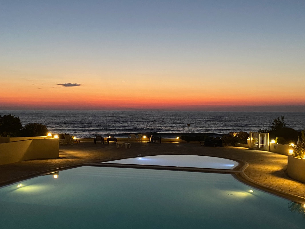 Colorful sunset with pool and the sea in Paphos